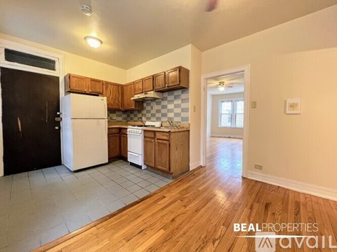 A kitchen with a black door and a white fridge.