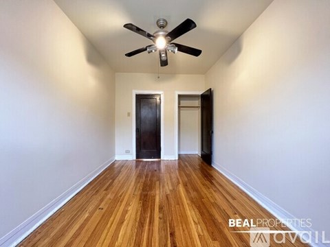 A room with a ceiling fan and wooden flooring.