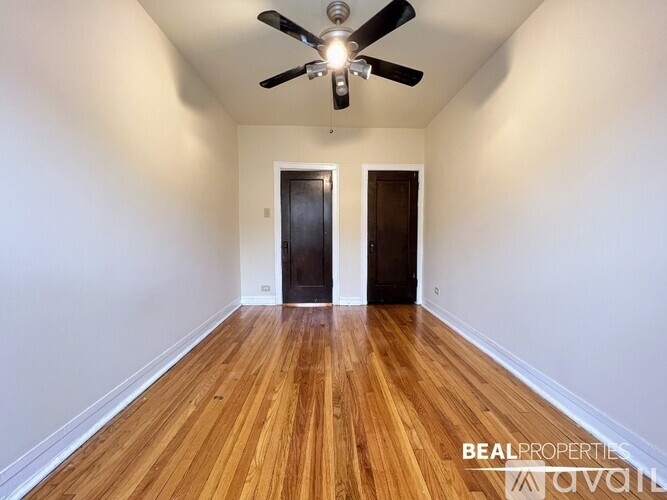 A room with a ceiling fan and wooden flooring.