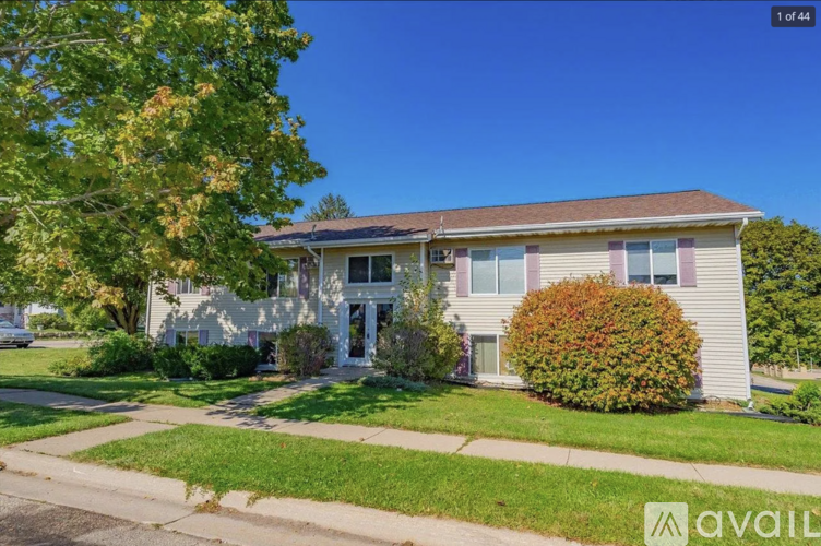 A house with a lawn and a tree in front of it.