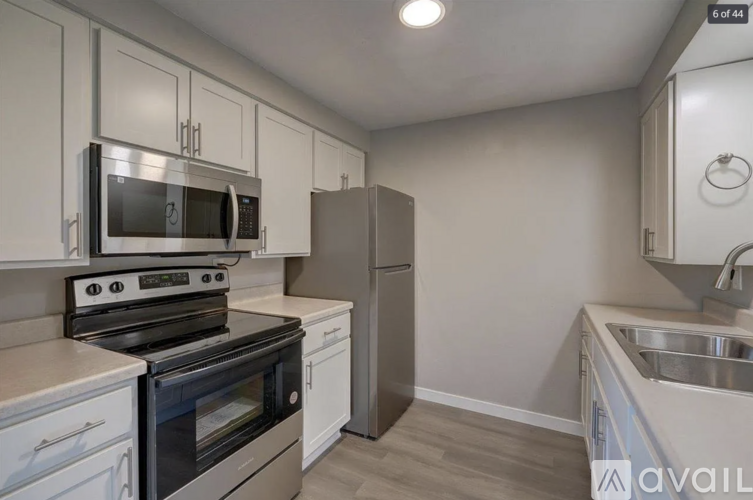 A kitchen with white cabinets and a black stove top oven.