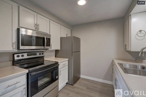 A kitchen with white cabinets and a black stove top oven.