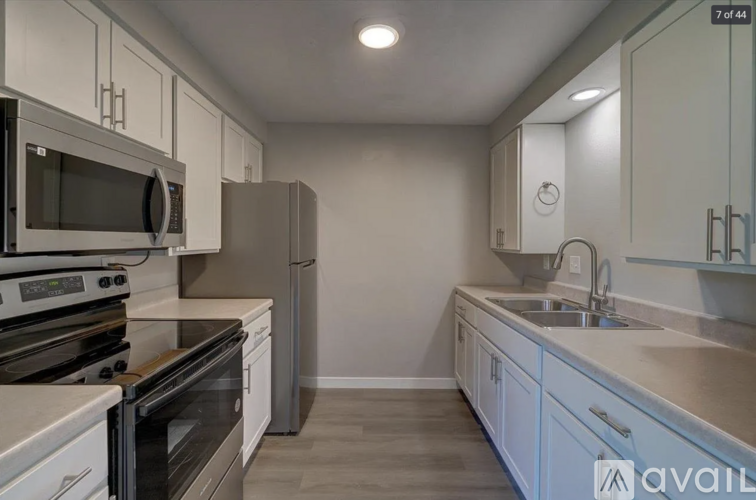 A kitchen with white cabinets and stainless steel appliances.