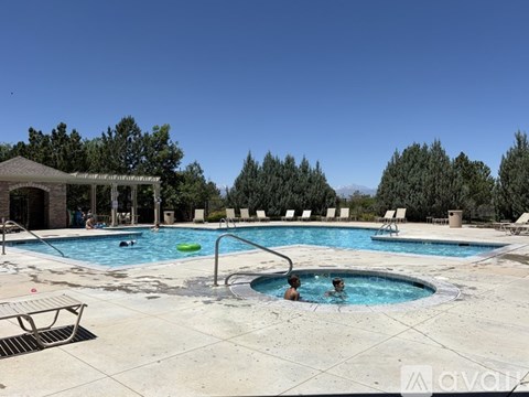 A pool with people in it and a gazebo in the background.