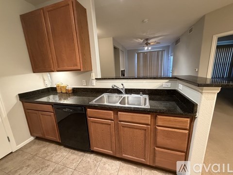 A kitchen with brown cabinets and black countertops.
