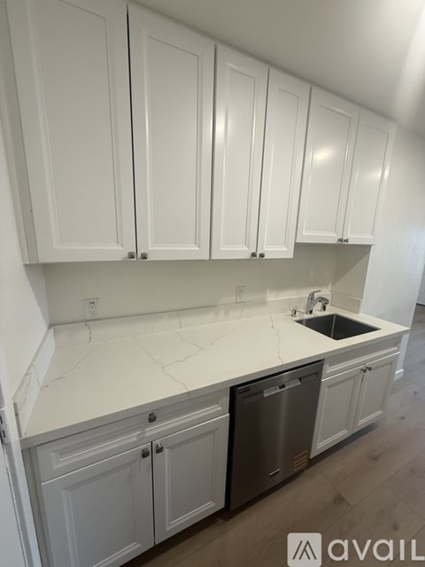 A kitchen with white cabinets and a sink.