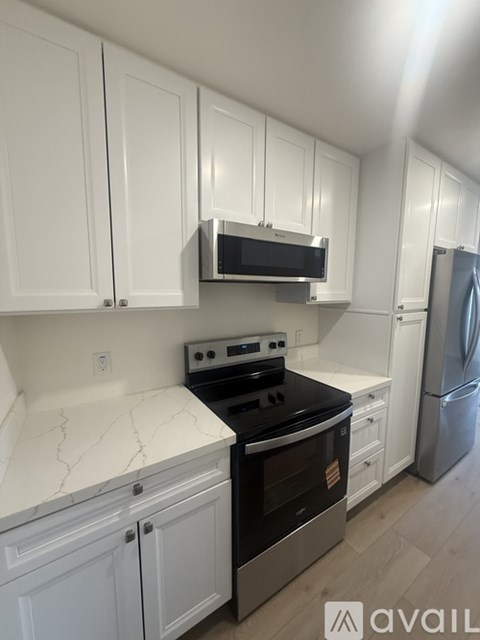 A kitchen with white cabinets and a black stove top oven.