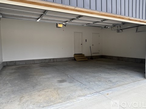 A spacious garage with a concrete floor and a metal roof.