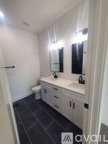A bathroom with a toilet, sink, and mirror.