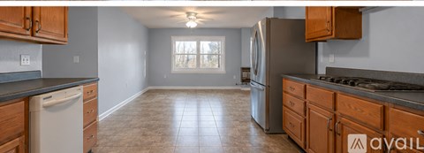 A kitchen with wooden cabinets and a tile floor.