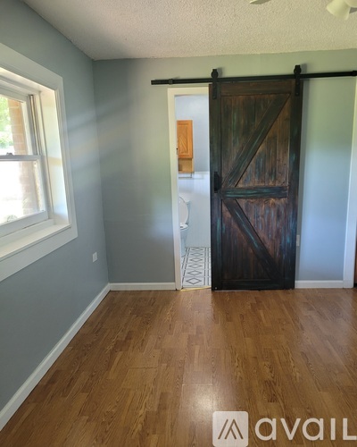 A room with a wooden floor and a sliding barn door.