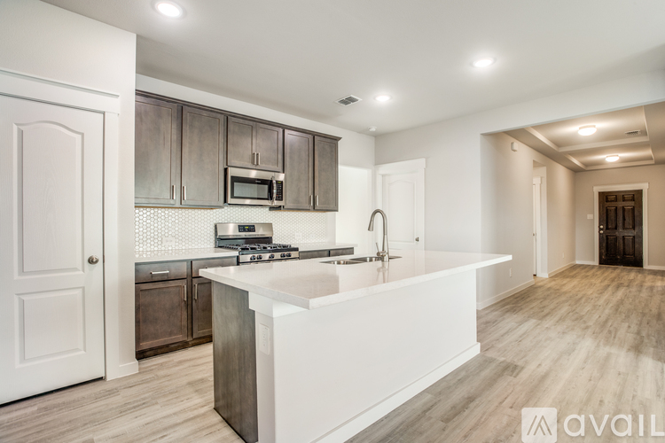 A modern kitchen with a white island and wooden floors.