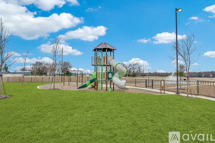 A playground with a green slide and a tower-like structure.