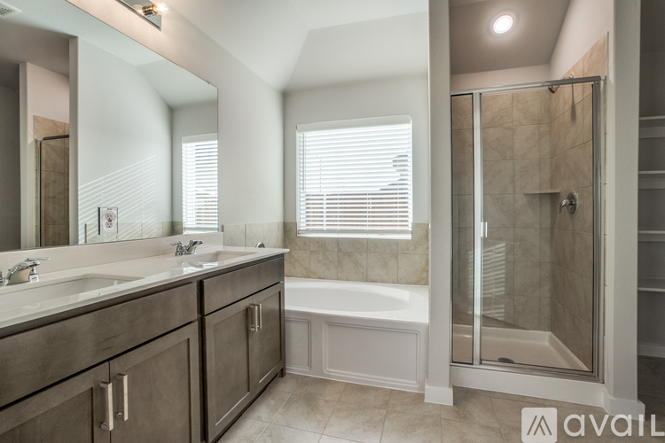 A bathroom with a tub, sink, and mirror.