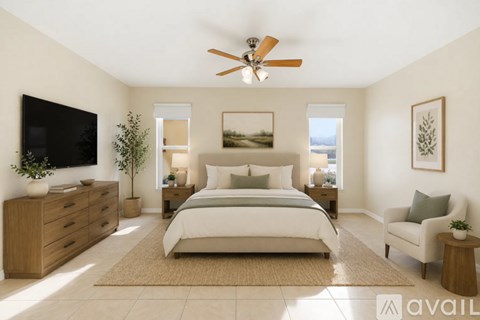A bedroom with a large bed, a TV, and a ceiling fan.