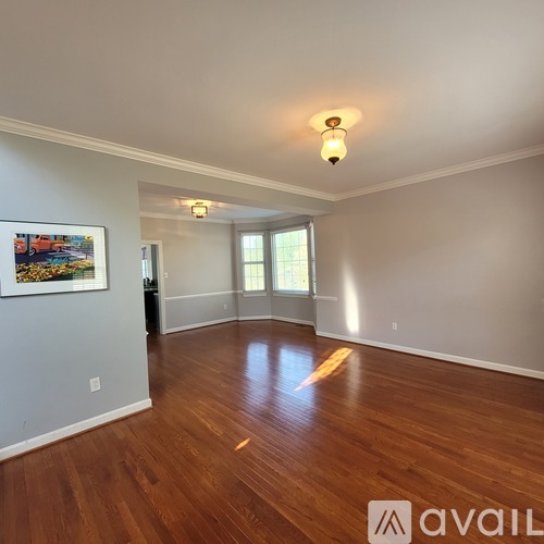 A room with wooden floors and a painting on the wall.