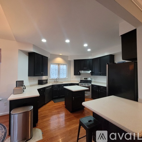 A kitchen with black cabinets and a white countertop.