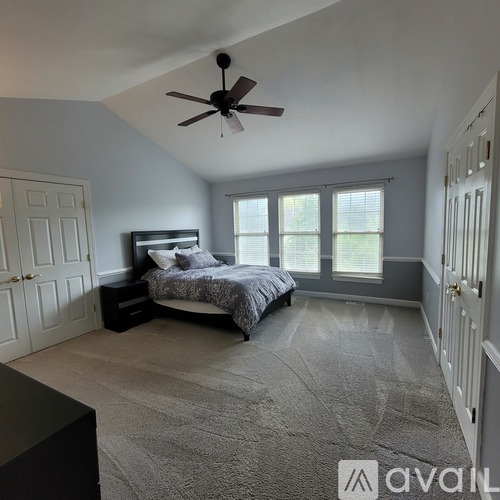 A bedroom with a bed, dresser, and window.