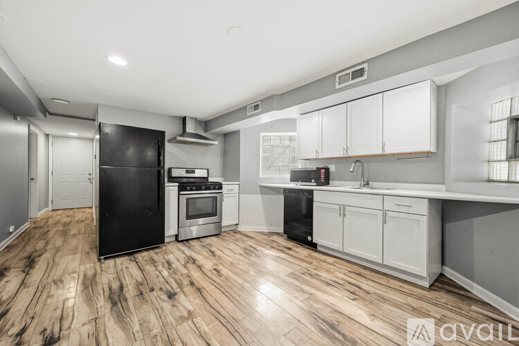 A kitchen with a black refrigerator, stove, and oven.