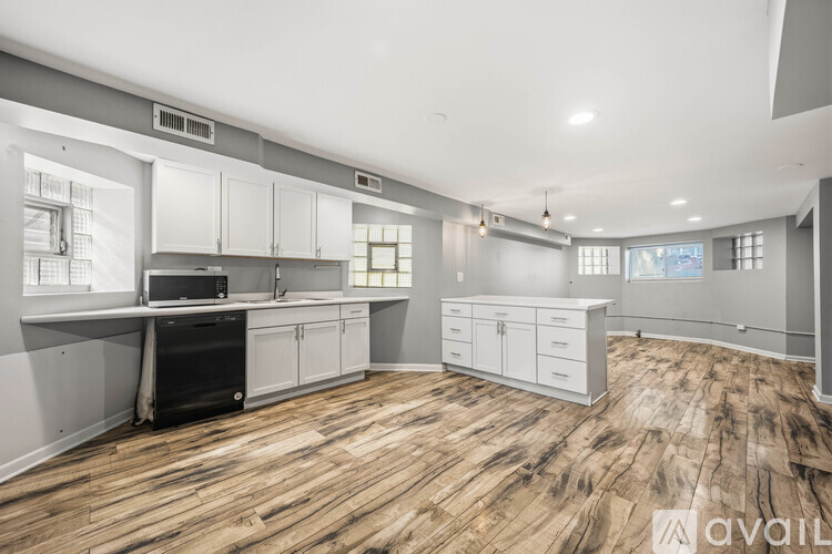 A kitchen with wooden floors and white cabinets is available for rent.