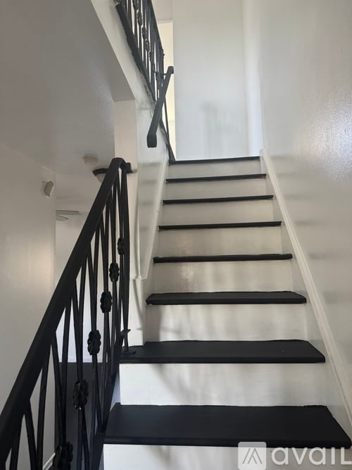A staircase with black steps and a black railing.