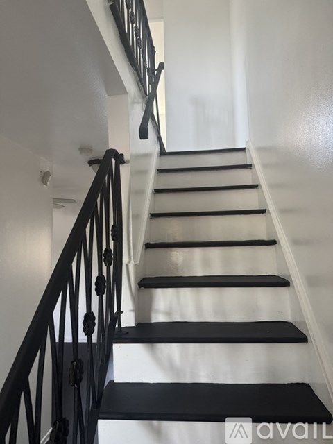 A staircase with black steps and a black railing.