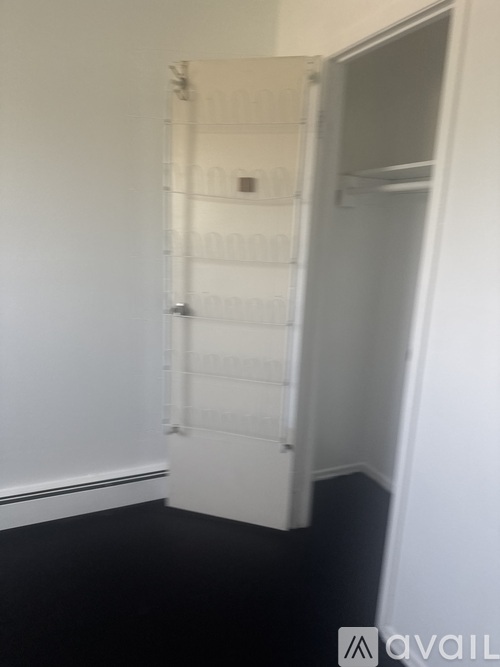 A white door is open to a hallway with white walls.