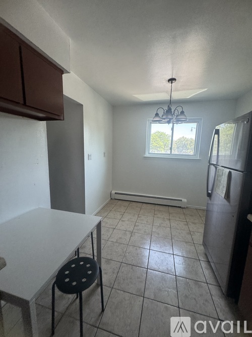 A kitchen with a table and a refrigerator.