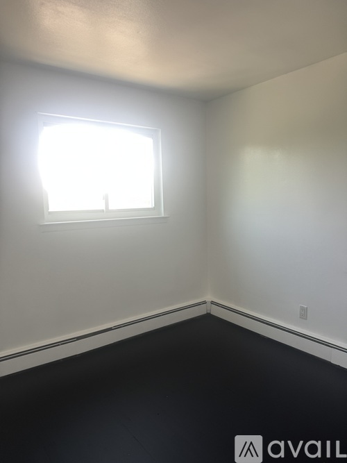A room with a window and a black floor.