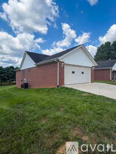 A house with a white garage door and a brick exterior.