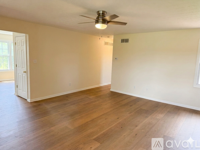 A room with wooden flooring and a ceiling fan.