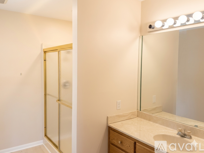 A bathroom with a vanity, mirror, and lights.