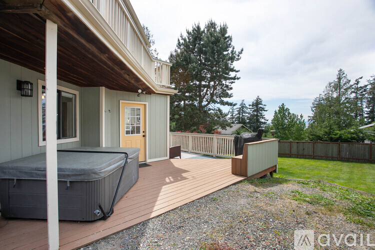A hot tub is on a deck outside a house.