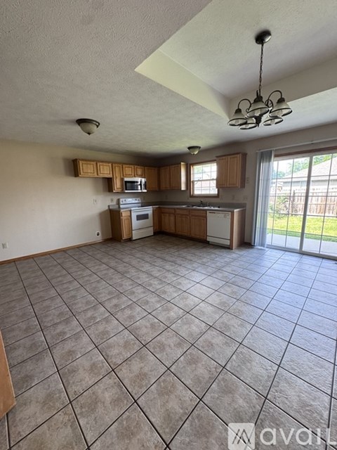 A kitchen with tile flooring and wooden cabinets.