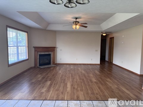 A living room with wood flooring and a fireplace.
