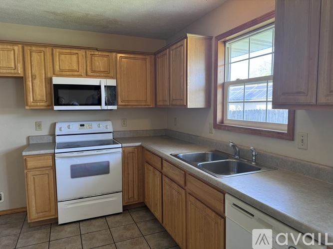 A kitchen with wooden cabinets and a white stove top oven.