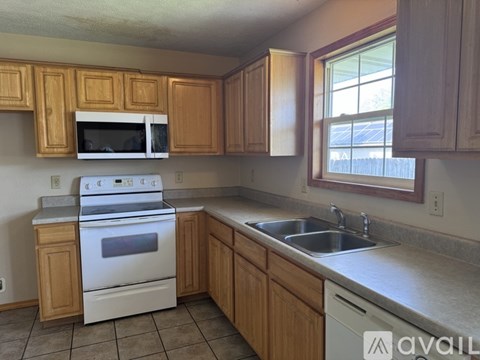 A kitchen with wooden cabinets and a white stove top oven.