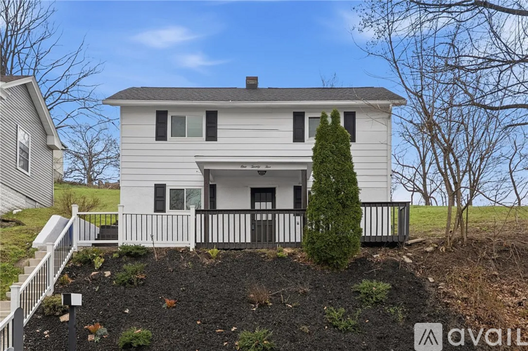 A house with a white exterior and a black fence.