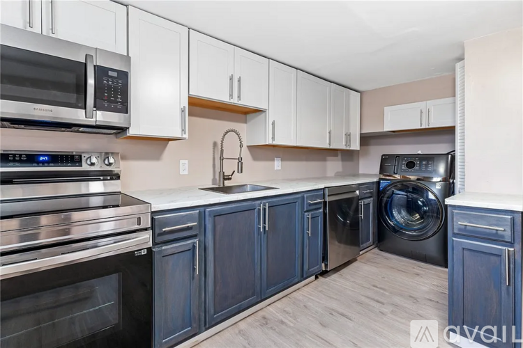 A kitchen with dark blue cabinets and stainless steel appliances.