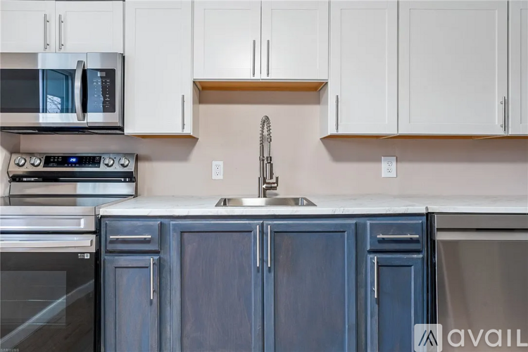 A kitchen with blue cabinets and white walls.