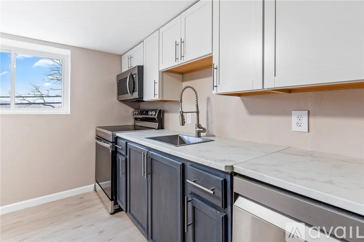 A kitchen with a microwave, oven, and sink.