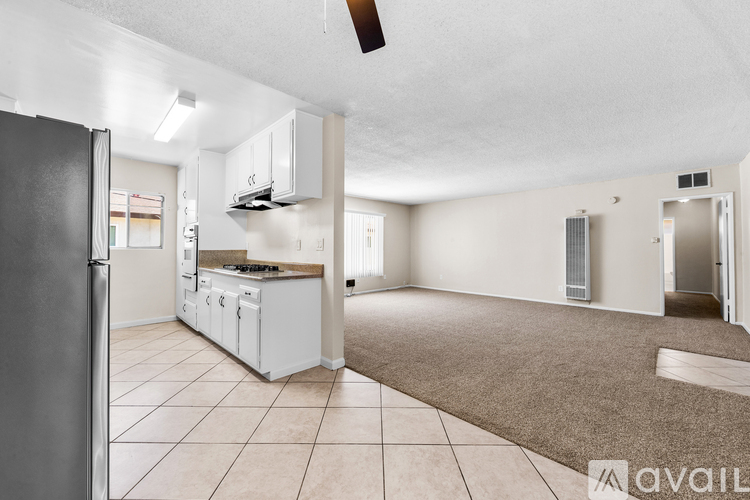 A kitchen with white appliances and a refrigerator is shown.