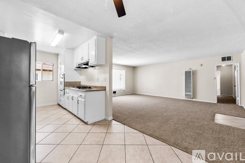 A kitchen with white appliances and a refrigerator is shown.