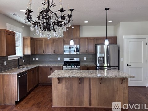 A kitchen with wooden cabinets and granite countertops.