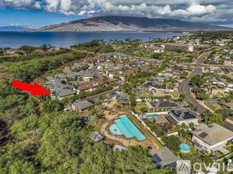 A red arrow points to a house in a residential area with a pool.