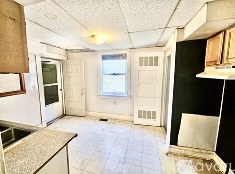 A kitchen with white cabinets and a black refrigerator.