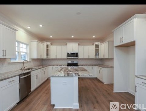 A kitchen with white cabinets and a central island.