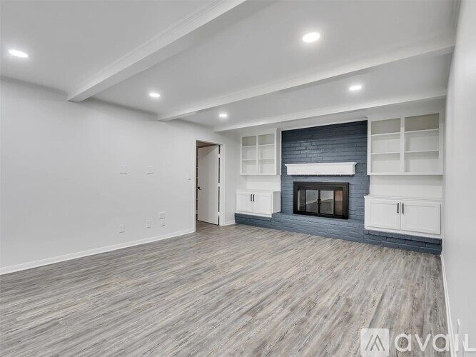 A spacious living room with a fireplace and built-in shelves.