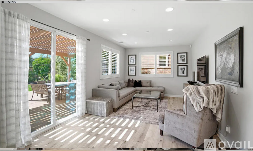 A living room with a couch, a rug, and pictures on the wall.