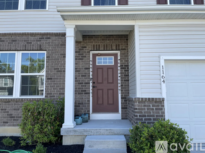 A house with a brown door and a white garage door.